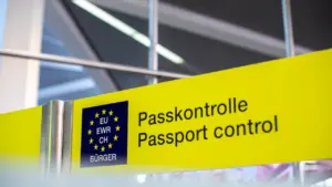 Kollane passikontrolli silt lennujaamas, mis viitab Euroopa Liidu piiridele ja reisijate kontrollile.