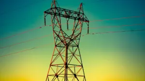 Kõrgepingeliinid ja elektripostid päikeseloojangu valguses elektrivõrgu olukorra illustreerimiseks.