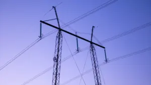 Kõrgepingeliinid ja elektripostid selge sinise taeva taustal Eestis.