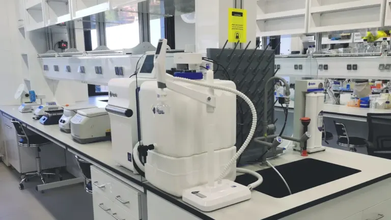 Moodne laboratooriumi töölaud teadusseadmetega, mis sümboliseerib teaduslikku uurimistööd ja pühendumist.